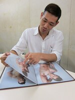 自身の宣材写真集を満足げに眺めるHG。