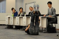 子供をあやしながらできる筋トレ方法を説明するワッキー。足に子供を乗せるという。