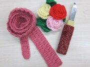 相方・望月のネクタイ、バラがモチーフのアクリルたわし、毛糸のカバーが付いた匕首。