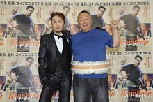 クールな男装で決めたはるな愛（左）と主人公のクリスと同じ衣装の松村邦洋。