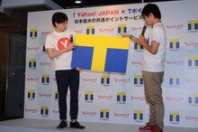 大きなTカードが登場し「カバンに入るかしら？」（吉村）、「でかいカバン買うしかないですね」（徳井）と話す平成ノブシコブシ。