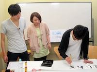 決定した番組タイトルを丁寧に書き上げていくザ☆忍者・山脇（右）。