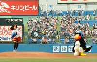 球を投じるキンタロー。（左）と、見守るつば九郎。