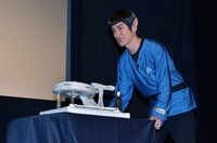 Mr.スポックに扮して特製バースデーケーキをカンバーバッチのもとへ運ぶココリコ田中。