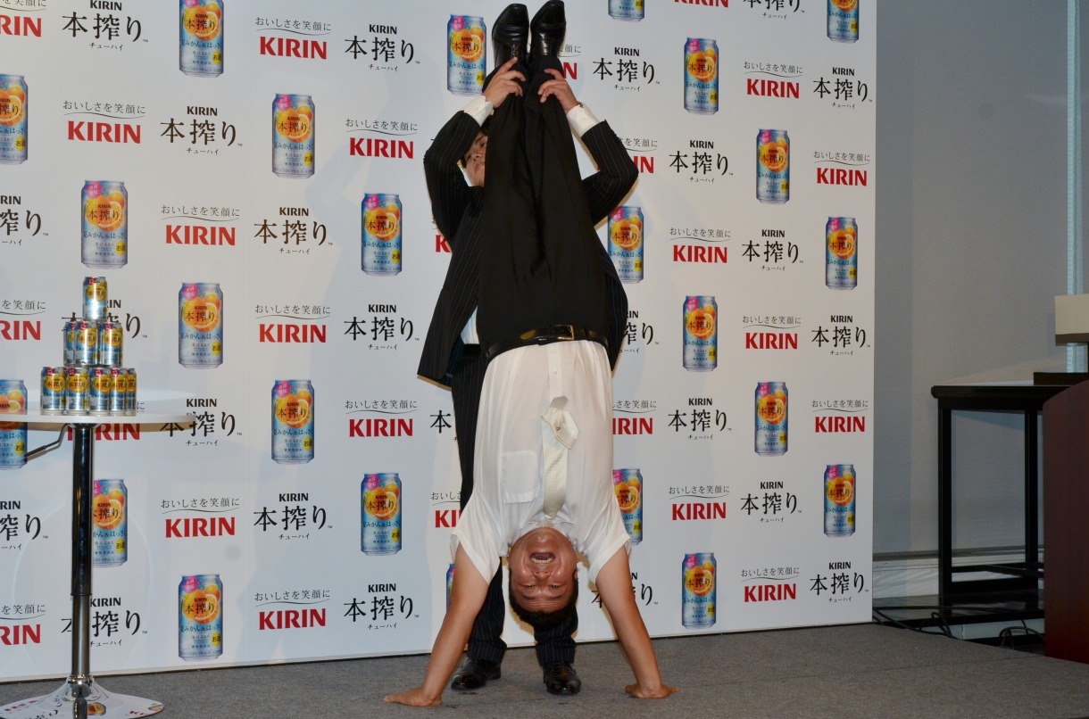 逆立ちをするアンタッチャブル山崎。背後ではスタッフがサポートしている。