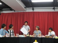 舞台で歌った歌の配信が決まったという発表をしようとした角田。巻物に何も書いていないことに呆然。