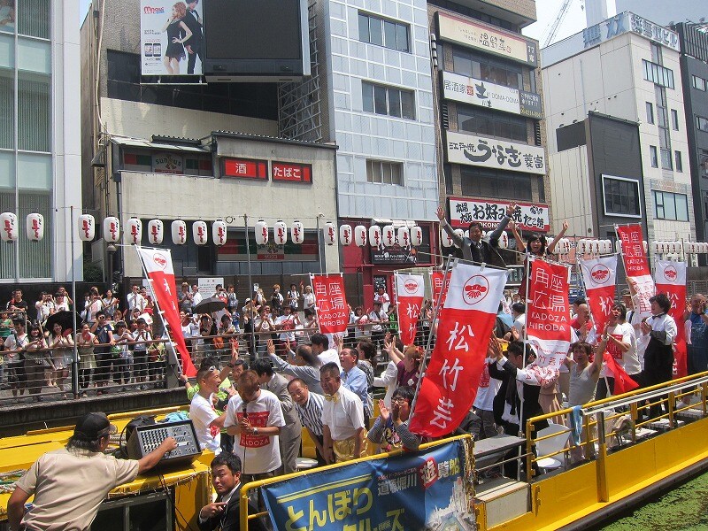 松竹芸能の新たなお笑い劇場「DAIHATSU MOVE 道頓堀角座」オープンを祝して道頓堀川から挨拶。