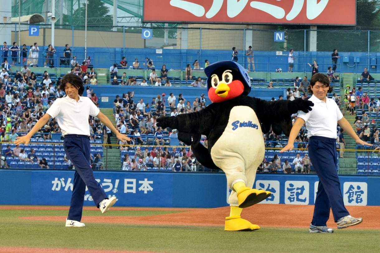 「あたりまえ体操」つば九郎バージョンを披露するCOWCOWと、つば九郎（中央）。