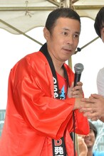 ファンと握手を交わしながら写真撮影に応じるナインティナイン岡村。