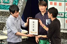 麒麟・川島（左）から、名前入りの「楽屋バリ」を手渡される、かたつむり林（右）。