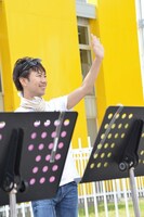 集まった大勢の観客や乗り物に乗っている人たちに手を振る藤井。