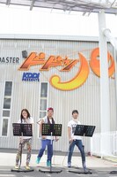 高飛車の行列の前で洋楽ステージを行う3人。