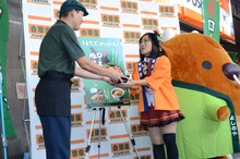 吉野家の店員から新商品「ロース豚丼 十勝仕立て」を受け取るキンタロー。。