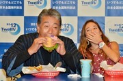 ハンバーガーにかじりつく高田純次（左）。会見は都内のハンバーガー店にて行われた。