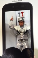 AQUOS PHONEの従来の画面の大きさを、体を使って表現するスギちゃん。