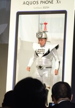 新しくなったAQUOS PHONEの画面だと頭をぶつけることなく通過できると説明するスギちゃん。