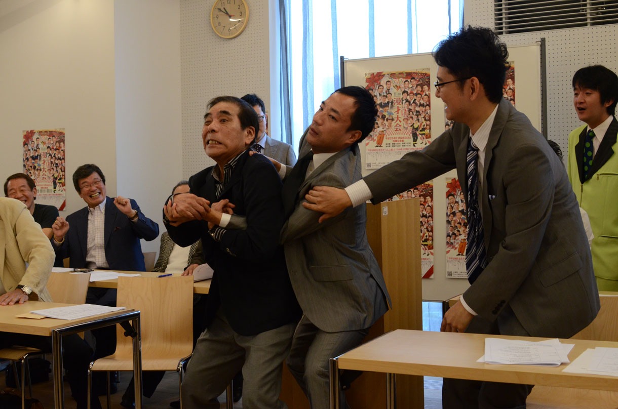 「あわや乱闘騒ぎ」という状況をカメラマン向けにパフォーマンスする青空球児とナイツ塙。