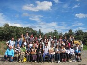 茨城・福田グリーン農園での集合写真。左下は参加者のために特大のさつまいもを育てた農園主。