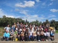 茨城・福田グリーン農園での集合写真。左下は参加者のために特大のさつまいもを育てた農園主。