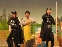 石田靖座長の吉本新喜劇「メガパワーマン登場」一場面。