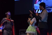 作中のキャラクター・ゼロに扮し、仮面姿でステージに登場した天津・向（左）。