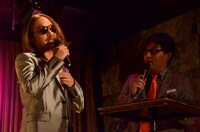 ウォーキング対決でさほどウケず、心が折れたことをMCのコトブキツカサ（右）に報告する山里（左）。