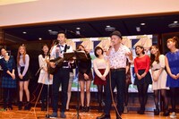 「どびーず」をバックに「イッツ・ロンリー・クリスマス」を披露する、どぶろっく（手前）。