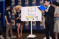 暗号を記したパネルを眺める芸人たち。