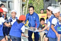 小学生たちとともに「はだしラン」に参加する、かもめんたる岩崎（中央）。