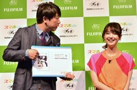 「スマホdeチェキ」の使い方をプレゼンする木本（左）と、佐々木希。