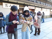 おみくじを引くヒロチョと落札者。