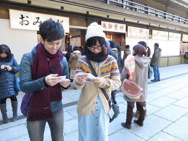 おみくじを引くヒロチョと落札者。
