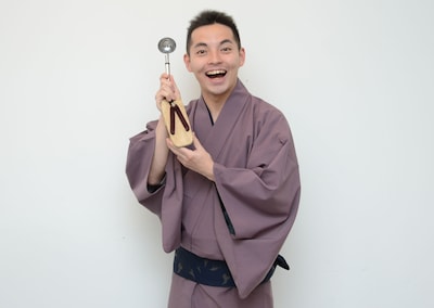 三遊亭こうもり。手にしているのは懐に収まるサイズの「おったまげた」。