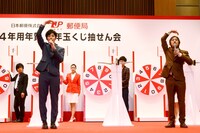 「立会人」として、ルーレットに刺さった矢の番号を確認し、「まる」のジェスチャーで承認するキングコング（手前）。