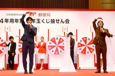 「立会人」として、ルーレットに刺さった矢の番号を確認し、「まる」のジェスチャーで承認するキングコング（手前）。