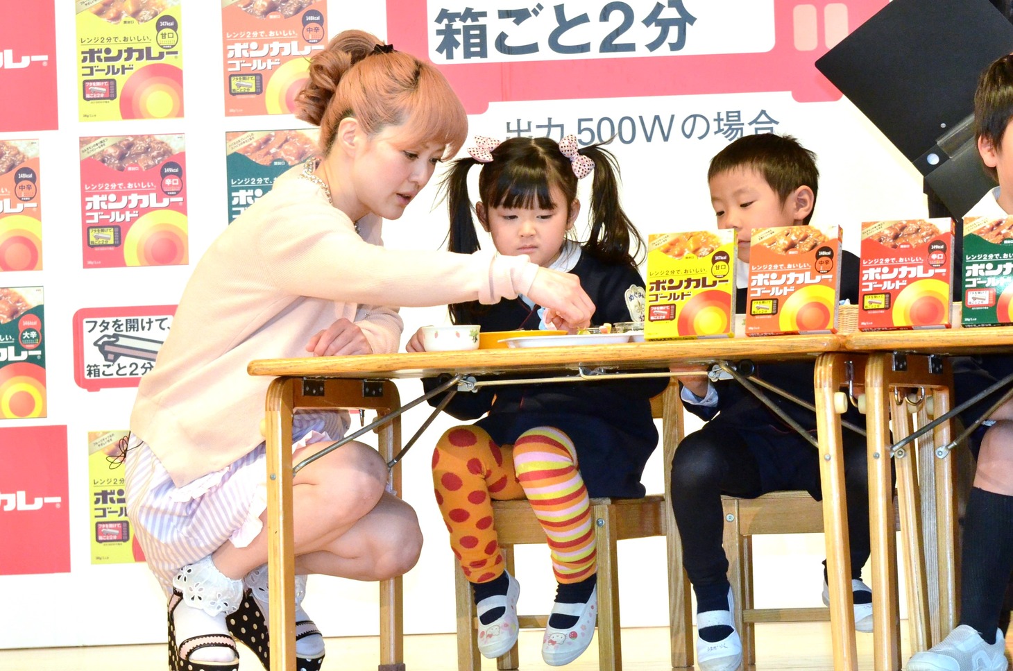 幼稚園児とともにカレーにトッピングを施す松嶋尚美（左）。