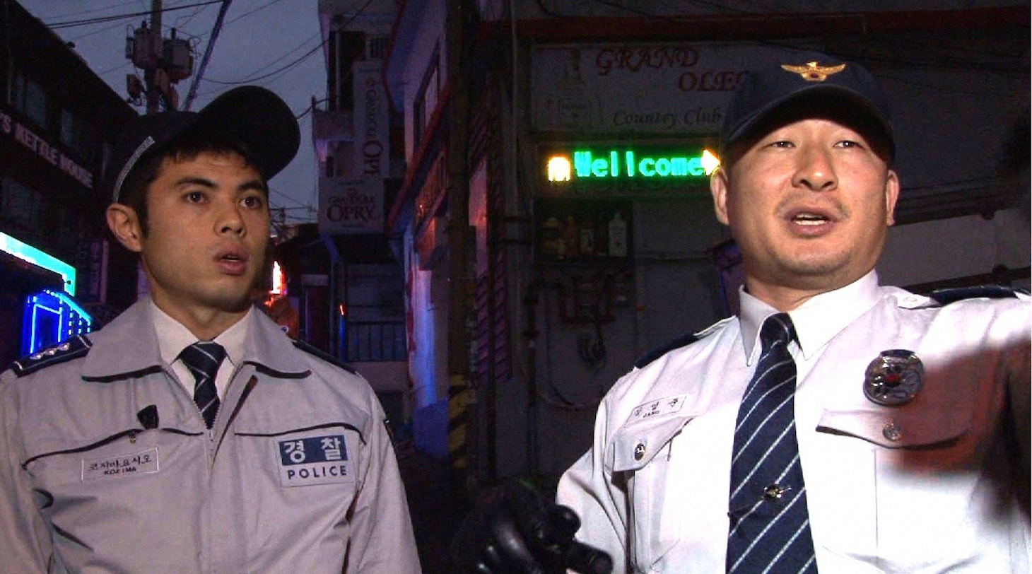 韓国でパトロールを行う警察官と小島よしお（左）。(c)テレビ朝日