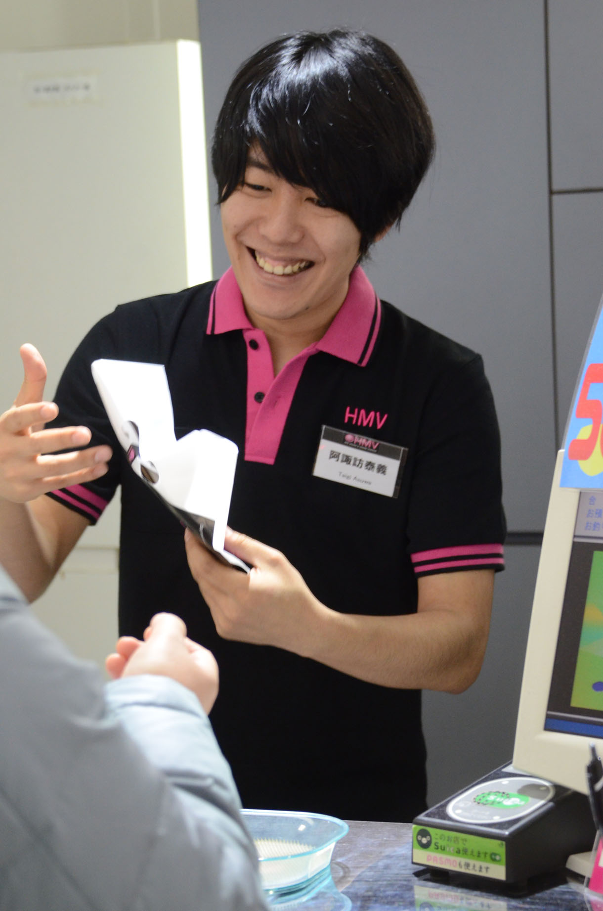 品物を購入者に手渡す阿諏訪。