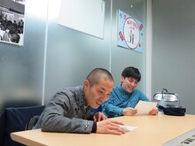 「ZERO」と書かれたシートを見るラブレターズ。