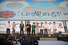 「第6回沖縄国際映画祭」の「X FACTOR OKINAWA JAPAN FINALIST SPECIAL LIVE」にMCとして登壇した博多華丸・大吉の華丸（左端）と、渡辺直美（右端）、パフォーマーたち。