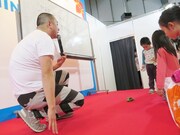 このイベントを企画したスバルの自動停止システムをミニカーで子供たちに実演するRG。