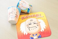 手前は茂造グッズのミニタオル（378円）、奥はメラミンコップ（473円）。4月23日から30日まで会場限定販売・先行販売。