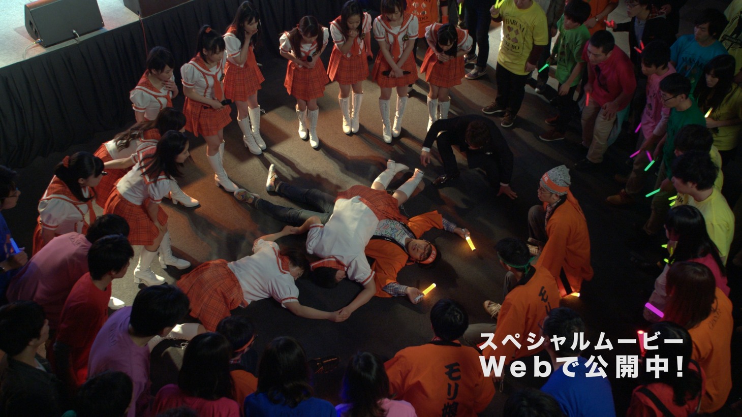 「au学割新CM『ライブステージ篇』」で、モリ娘。ファンの山里が森三中・大島と黒沢の下敷きになる場面。