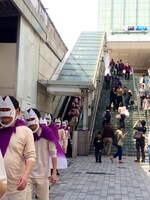 ミラクルエースのお面を被った集団が新宿の街を闊歩する様子。