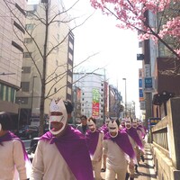 ミラクルエースのお面を被った集団が新宿の街を闊歩する様子。