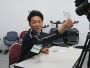 別室でスクラッチをひたすら削る嶋佐。200円が当たり喜びの笑顔。