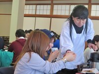 割烹着を生かして給仕をするある子。