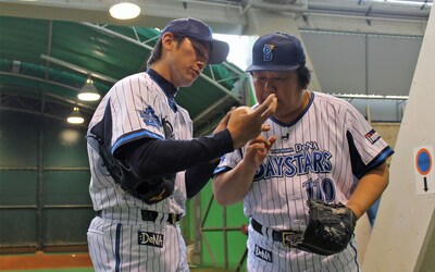「木曜ミステリー 刑事110キロ」第2弾の放送を前にプロ野球の始球式に登板し、三浦大輔投手（左）に指導を受ける石塚英彦（右）。(c)テレビ朝日