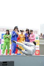 体操を踊ろうとしたところをすかされて転倒する南海キャンディーズ山里（手前）。