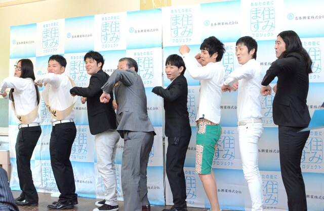 「せーの！ ワクワク！」とプロジェクトの5か条を紹介する芸人たちに混ざる大久保市長（左から4人目）。